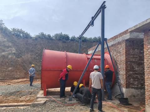 技术人员在砖砌风机房旁安装并对中红色矿用通风机